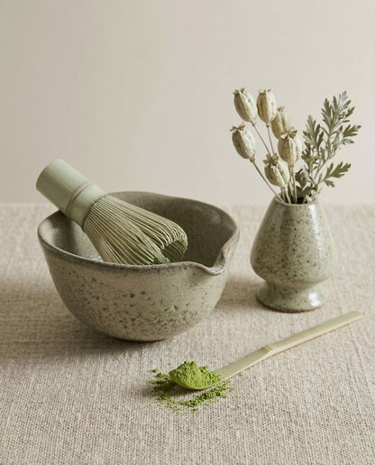 Yeşil matcha seti keten örtü üzerinde, çırpıcı ve kaşıkla